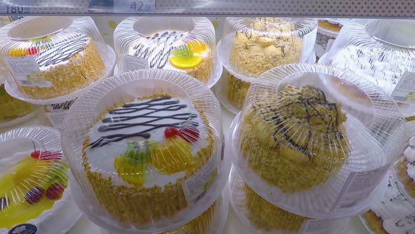 Window of a cake shop with a variety of cakes on display. Pies and cakes Dessert store. Pastry shop with of donuts, muffins, creme brulee, cakes with fruits and berries