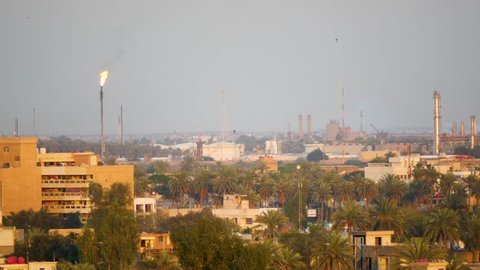 Baghdad, NA / Iraq - 04 15 2018: Baghdad, Iraq April 2018: Panorama of the Baghdad skyline and oil field at sunset