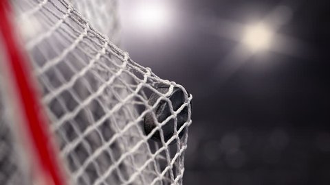 Hockey puck flies into the net. Beautiful close-up 
