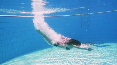 Young girl dive in swimming pool, underwater slow motion 库存视频