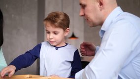 Mother, father, and son are playing checkers in the living room; boy rolls the dice and makes a move - Powered by Shutterstock - Get 15% off with code: PIKWIZARD15