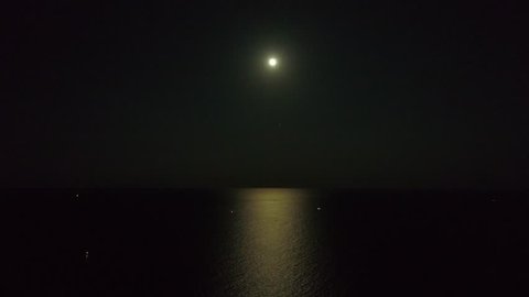 Aerial night footage moon over ocean