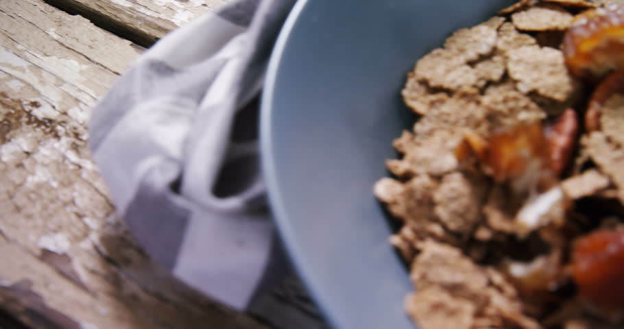 Close-up of wheat flakes with dried fruits in a bowl 4k