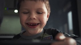 Young Cute Boy Playing With a mobile phone and make funny faces at Home