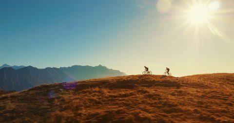 Aerial tracking of mountain bikers on cross-country cycling in amazing sunlight.