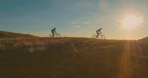 Aerial tracking of mountain bikers on cross-country cycling in amazing sunlight.