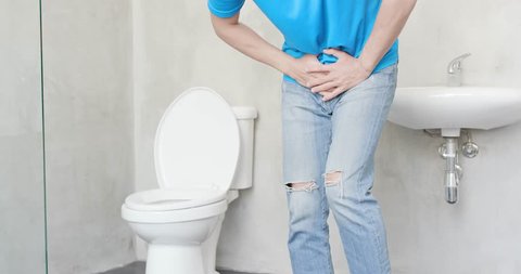 man with urine urgency in the toilet