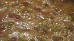 Preparing of stew with meat and peas 4K footage
