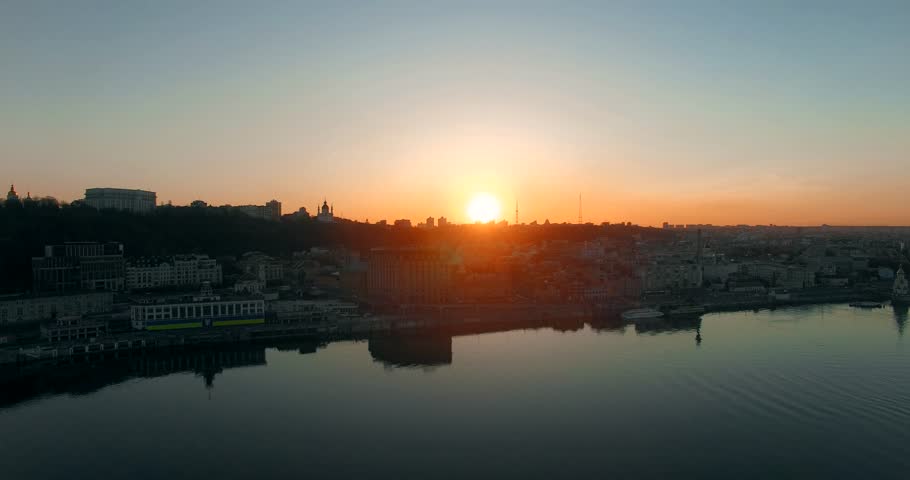 Kiev Ukraine Aerial View In Golden And Blue Hour Megapolis. Sunset Over Kiev City. Aerial Sunset Water Under Dnieper River. Sunset Golden Light And Reflection On Water In Aerial Drone Ukraine City