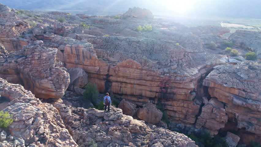 Male rock climber standing over a rocky mountain at countryside 4k