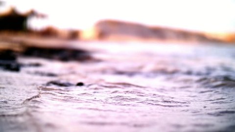 close-up, sea surf On the Sunset, clear water covers sand. small waves with bubbles, Soft sea wave on sandy beach. Sea beach