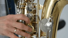 Man hand with gold ring playing saxophone close up