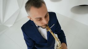 musician in suit and bow tie playing the saxophone. music clip shooting. top view