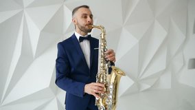 Musician in suit and bow tie playing the saxophone. Music clip shooting.