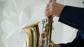 musician in suit and bow tie playing the saxophone. music clip shooting