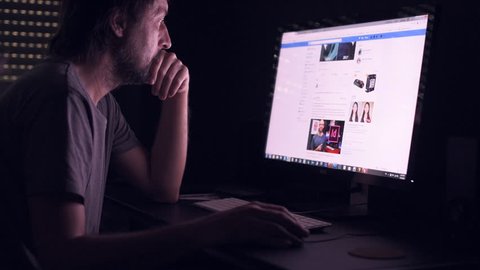 NOVI SAD, SERBIA - MAY 4, 2018: Man is browsing Facebook news feed page on his home computer. Facebook is worldwide known social networking service with over 2.20 billion active users in 2018.