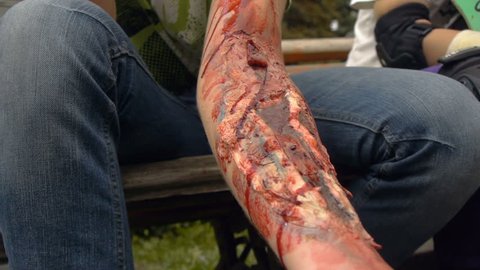 Fake wound on the guy's hand, bleeding wound on the arm of the zombie, halloween make-up