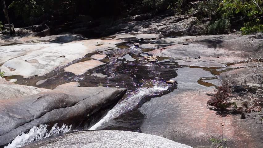 Stones and mountain river with small waterfall in jungle on tropical island