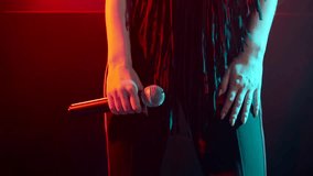 The singer with a microphone in her hand dances on stage - Powered by Shutterstock - Get 15% off with code: PIKWIZARD15