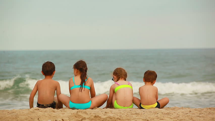 Children sit on the beach