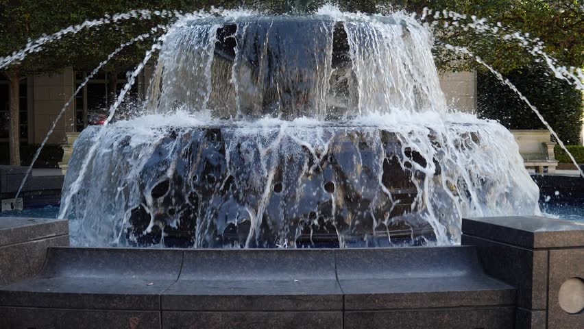 Water flowing over a classic ornamental two tier fountain outdoors in a park in Nashville Tennessee