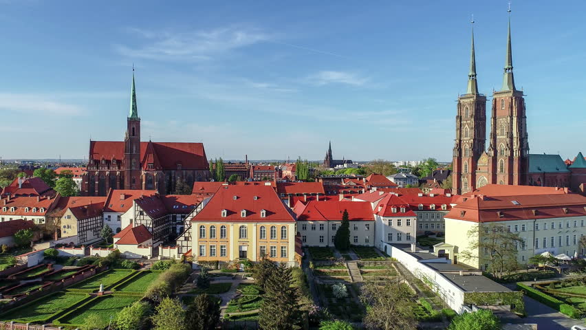 Poland. Wroclaw. Ostrow Tumski, Gothic cathedral of St. John the Baptist,  Collegiate Church of the Holy Cross and St. Bartholomew, park and Odra (Oder) River. Aerial 4K reveal footage at sunset.