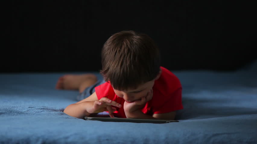 Boy is playing on a mobile phone.