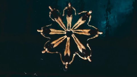 group of synchronized swimmers performing underwater