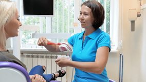 4k video of female dentist explaining importance of teeth hygiene to her patient