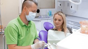 4k video of dentist writing prescription to his female patient