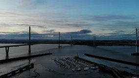 Aerial drone footage of Queensferry Crossing bridges over Firth of Forth bay, Scotland, United Kingdom. 