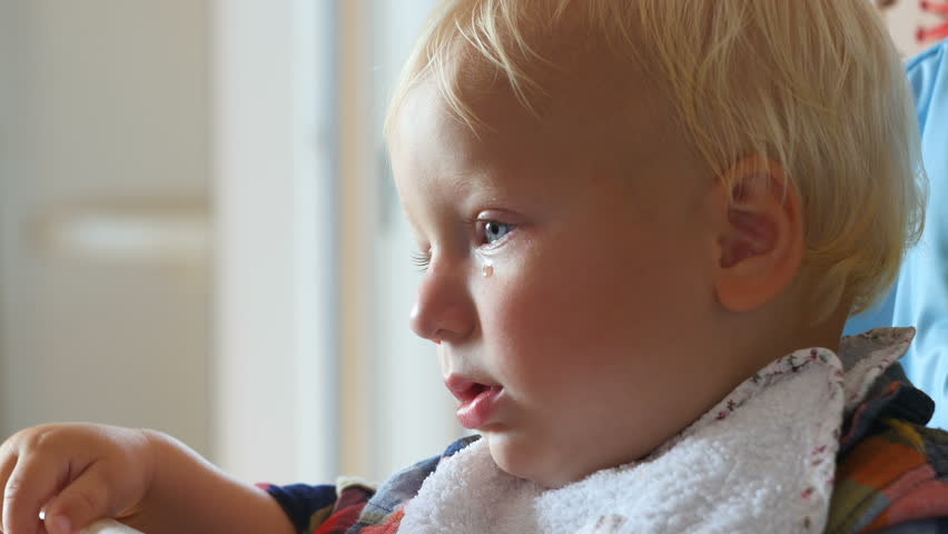 upset baby with teardrop on the cheek
