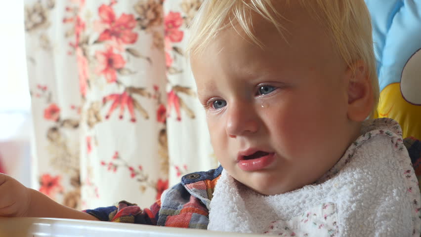 upset baby with teardrop on the cheek