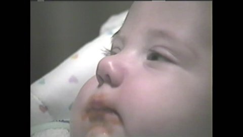A chubby baby is eating carrots. 1980's Vintage Video