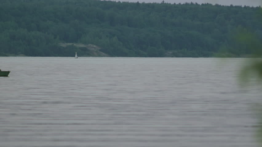 Fisherman Swims on a Green Boat in the Evening
