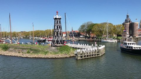 Enkhuizen, the Netherlands - May 6, 2018: Passing de harbor of the historical Dutch town of Enkhuizen. A pleasure boat exits the port of Enkhuizen.