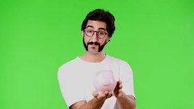 young crazy man with a rare beard holding a piggy bank. cutout against green chroma key background