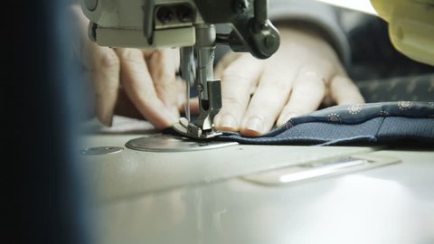 Macro shot of process of sewing male jacket with sewing machine. 4K.