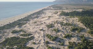 Forward high altitude aerial drone video towards tall sand dune mountain and Mediterranean Sea, beach in Patara, Turkey. 4k at 23.97fps