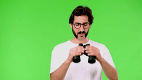 young crazy man with a rare beard and binoculars. cutout against green chroma background