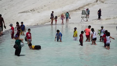 Pamukkale, Turkey, May 3, 2018. A crowd of tourists visiting the travertine pools at Pamukkale or "cotton Castle" - extraordinary natural beauty .  