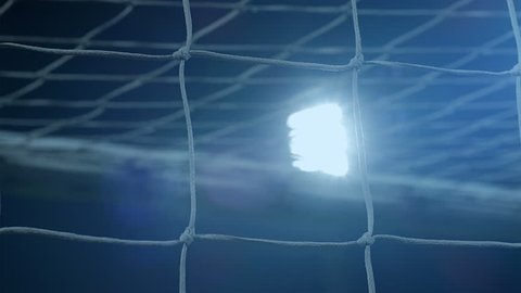 Background of football/soccer/sports stadium lights agains dark sky, net in front, 4k
