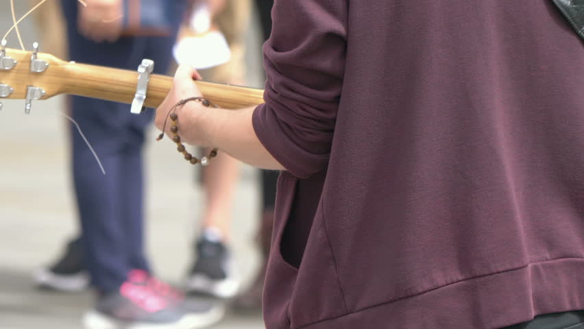 
Professional video of Young musican player on a city street in 4K slow motion 60fps