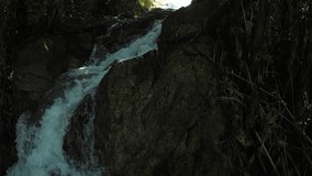 Man climbing a waterfall in a wild tropical forest. First Person View video