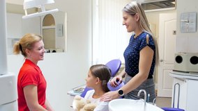 4k video of young mother with teenage girl talking to dentist in dental clinic