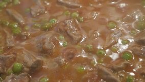 Close-up of meat stew with green peas 4K video