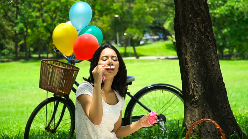 Beautiful girl blowing bubbles. In the outdoors. Activities during childhood. Make fun. Slow Motion.
