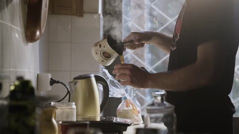 Man Pouring Steaming Fresh Made Coffee In A Coffee Cup