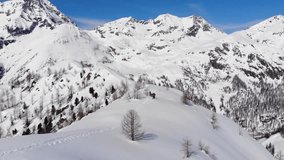 Aerial video. Group of ski touring on skin uphill in a line. Drone shot Ski touring in big mountains, beautiful landscape with high peaks in background. Aosta Valley Monterosa Gressoney. 