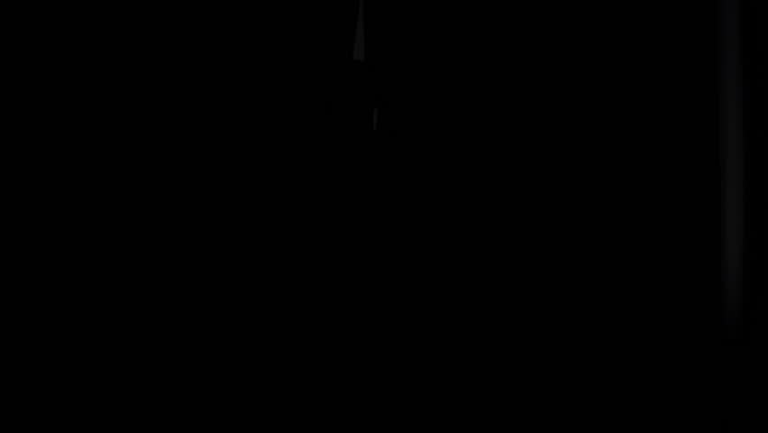 Man silhouette in dark room opening curtain to light. Person looking at street life out of window, taking long look away, to outside scene. Inhabitant of big city concept. Filmed 4K on Sony a6300 in